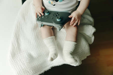 a very small child plays with the joystickの写真素材