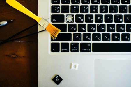 screwdriver and spare parts from a laptop. Keyboard, brush, keys. Laptop repair.の写真素材