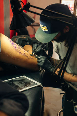 Tattoo artist workplace with machine and bottles with black tattoo ink.のeditorial素材