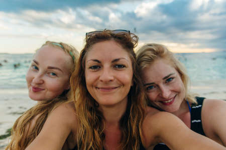 beautiful girls in glasses take a selfie on a background of blue water on the beach Playa Norte, Isla mujeres. Mexicoの写真素材