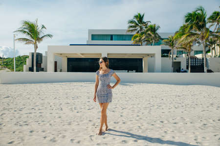 sexy beautiful woman in dress poses on the beachの写真素材