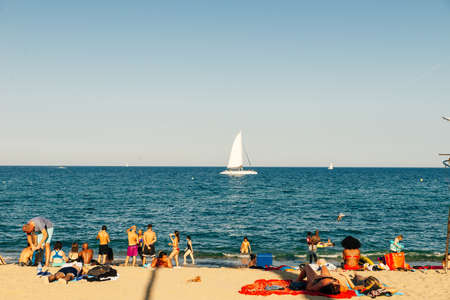 Tourists rest along Barceloneta beach. Barcelona, Spain - May 2019.のeditorial素材