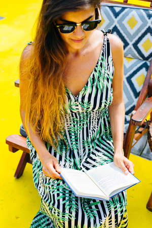 girl in a bright dress is reading a bookの写真素材