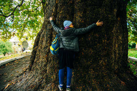 Telavi, Georgia - girl hugs a huge tree. Kakheti region. Georgia.の写真素材