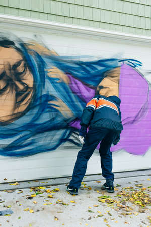 canada, toronto - december, 2019 Graffiti artist spraying the wall.のeditorial素材