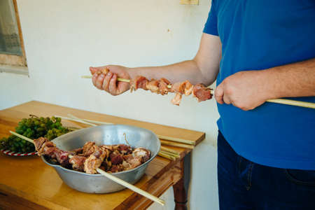 man is preparing meat for barbecue. meat skewer.の写真素材