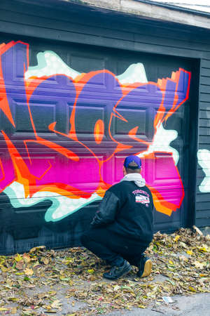 canada, toronto - december, 2019 Graffiti artist spraying the wallのeditorial素材