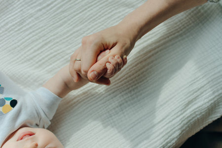 Newborn children's hand in mother hand. Mom and her Child.の写真素材