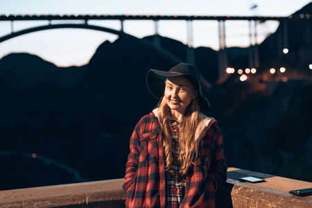 girl on the background of the bridge in the evening. Hoover Dam at Nevada.