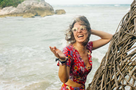 blonde in a bright dress on the background of the ocean.の写真素材
