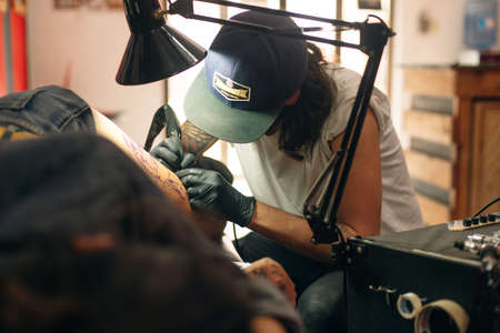 Tattoo artist workplace with machine and bottles with black tattoo ink.