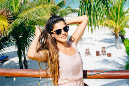 beautiful girl in sunglasses in a bright dress and dark hair in a bright interior.の写真素材