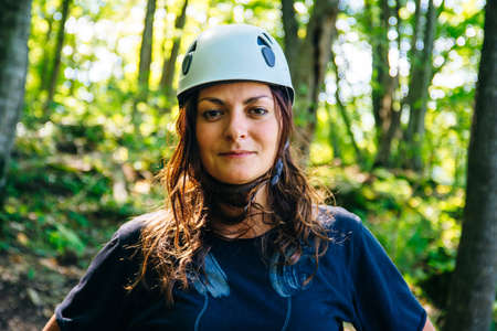 Close-up portrait of a girl in a helmet in the forest.