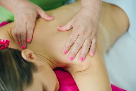 woman masseur doing girl massage in Spa salon close-up.の写真素材