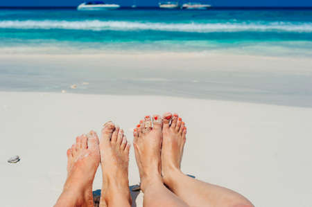 Young woman looking down pov point of view perspective on bare feet standing in white sandの写真素材
