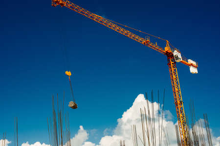 Yellow Industrial Cranes Working on Construction Site Against Blue Sky.の写真素材
