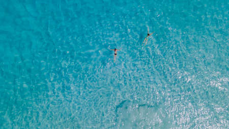Couple of woman floating in clear blue ocean. Aerial view. High quality photoの写真素材
