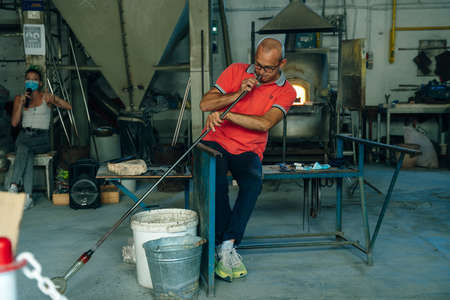 Murano, italy - nov, 2021 Glass blower demonstrate their craft for tourists on the historic properties, a popular tourist attraction. High quality photoのeditorial素材