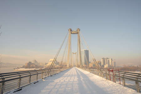 snow-covered bridge over the river in the winter in the sunrise Russia, Krasnoyarsk Vinogradovsky...