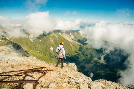 Tourist girl on the hike on the rock in High mountains and enjoying the magnificient view of the valley . high quality photoの写真素材