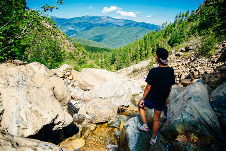 Tourist girl on the hike on the rock in High mountains and enjoying the magnificient view of the...
