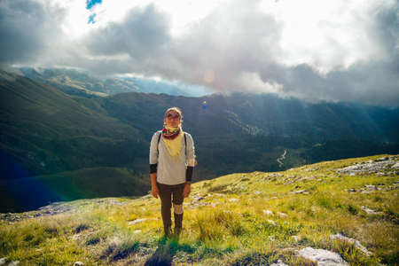 Tourist girl on the hike on the rock in High mountains and enjoying the magnificient view of the valley . high quality photoの写真素材