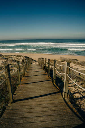 The wooden stairway on the rocky seashore on a sunny day. beach in Portugal. high quality photo