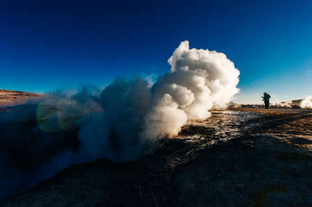 A man in the geysers at bolivian highlands Sol de la Manana, Uyuni Desert - December, 2018.の写真素材