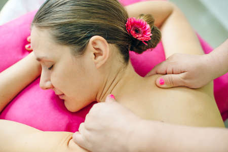 woman masseur doing girl massage in spa salon close-up.の写真素材
