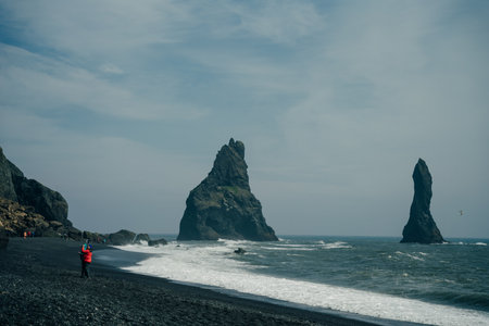 The black sand beach of Reynisfjara and the mount Reynisfjall from the Dyrholaey promontory in the southern coast of Iceland. high quality photoのeditorial素材