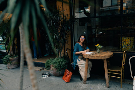 young girl at a table in a cafe with a notebook. high quality photoの写真素材