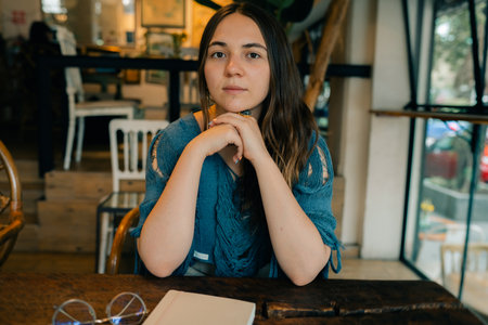 young girl at a table in a cafe with a notebook. high quality photoの写真素材