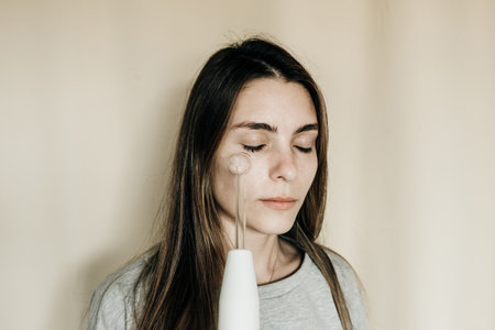 Woman using high frequency darsonval device for face. high quality photo