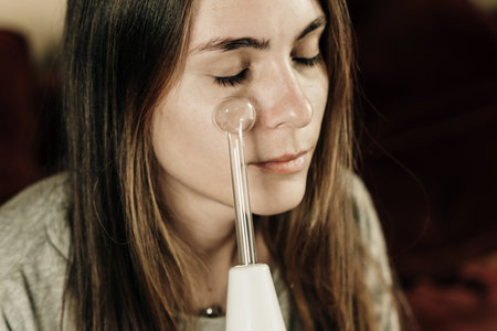 Woman using high frequency darsonval device for face. high quality photoの写真素材