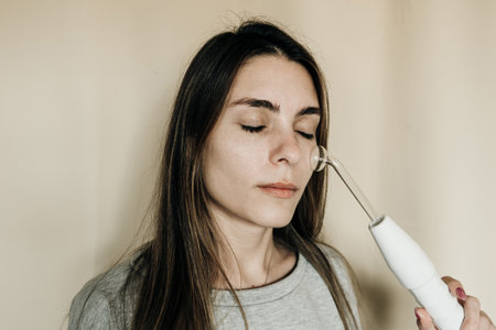 Woman using high frequency darsonval device for face. high quality photoの写真素材