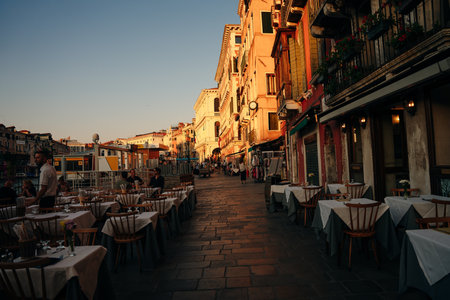empty restaurant tables at sunset in venice, italy - may 2023. High quality photo