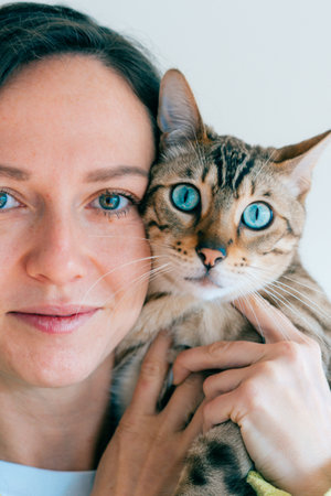 portrait of a girl and her bengal cat. blue eyes. high quality photo