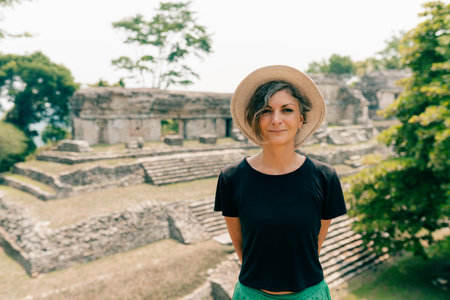 Hiker man with a hat looking at ancient Mayan ruins. high quality photoの写真素材