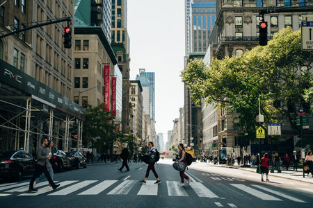 Busy street scene in New York City with groups of people walking across a crowded intersection on Fifth Avenue in Midtown Manhattan NYC. high quality photoのeditorial素材