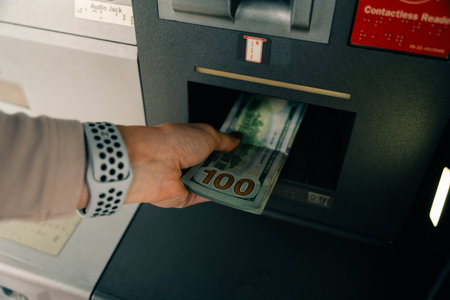 woman taking money from an ATM. high quality photoの写真素材