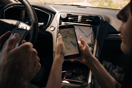 young couple in a car looking map in smartphone for direction. high quality photo