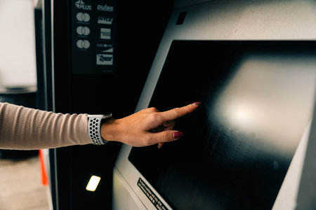 girl clicks on the screen at the ATM. High quality photoの写真素材