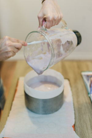 woman is holding glass of whites cream for the cake. fills the cake with cream. High quality photo