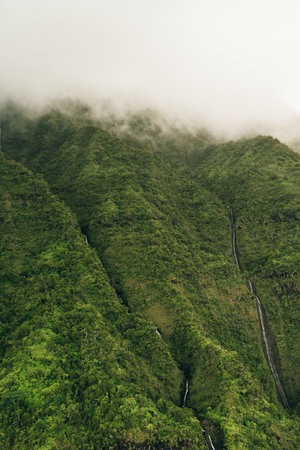 Clouds swirling around mountains of kauai as seen from helicopter
