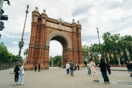 Barcelona, Spain - may 4 2024 Tourists walking and looking at Arco de Triunfo. High quality photo