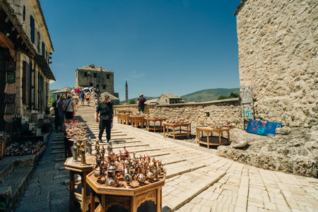 street with local shops and shoppers in Mostar, flanked by traditional architecture - July 10, 2024. High quality photoのeditorial素材