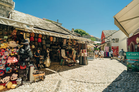 street with local shops and shoppers in Mostar, flanked by traditional architecture - July 10, 2024. High quality photoのeditorial素材