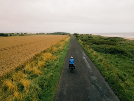 Aerial shot of a female cyclist crossing fields in England. High quality photoの写真素材