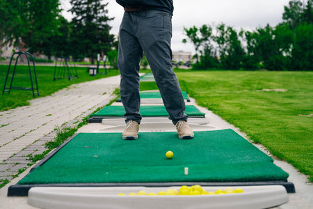 Golfer playing adventure or mini golf and trying putting ball into hole. Sports and leisure activityの写真素材