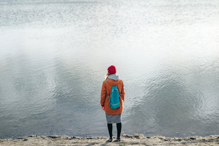 Hiker girl wrapping in warm clothes outdoor. Hiking in mountains in autumn. Bad weather with fog....